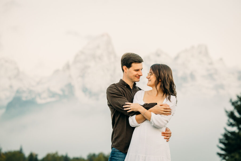 GTNP Schwabacher's Landing Engagement Couple newly proposed to with misty Teton mountain range, white dress