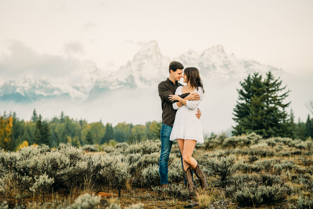 GTNP Schwabacher's Landing Engagement Couple newly proposed to with misty Teton mountain range, white dress