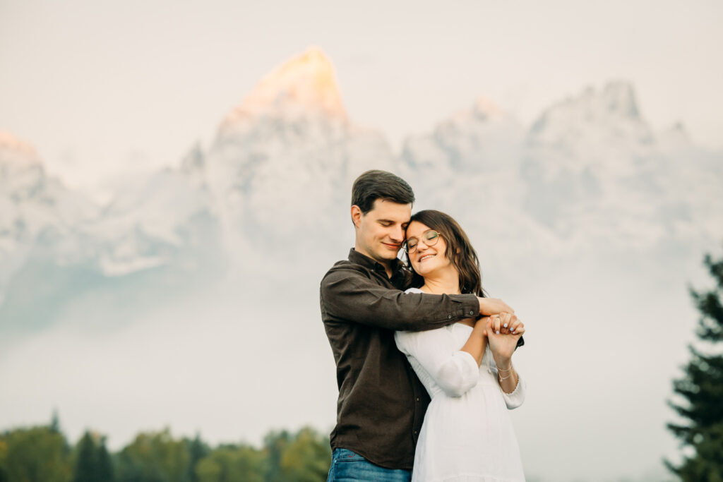 GTNP Schwabacher's Landing Engagement Couple newly proposed to with misty Teton mountain range, white dress