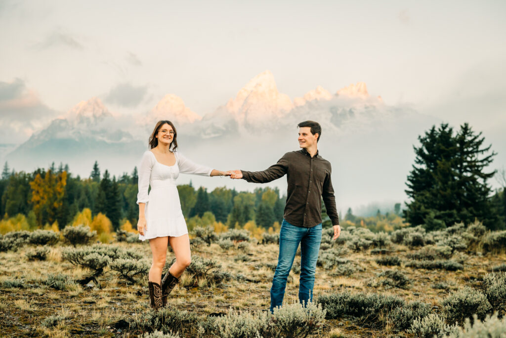 GTNP Schwabacher's Landing Engagement Couple newly proposed to with misty Teton mountain range, white dress