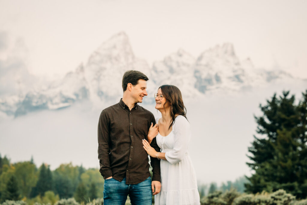 GTNP Schwabacher's Landing Engagement Couple newly proposed to with misty Teton mountain range, white dress