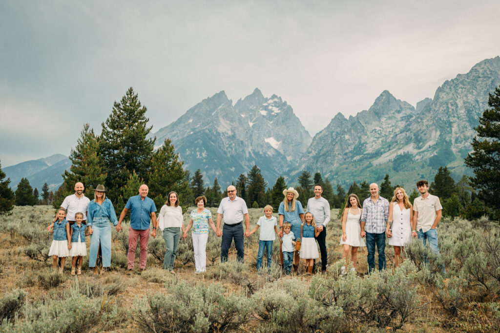 Extended family portrait with Grand Teton mountains at Cathedral Group Turnout