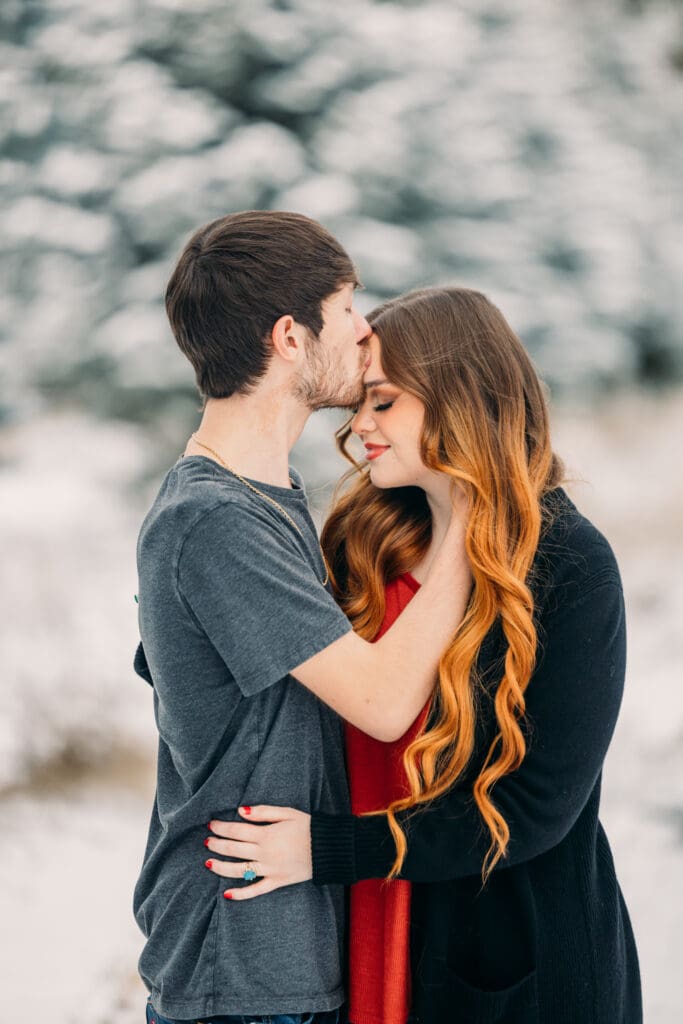 Winter proposal under snow-covered pine trees in Island Park
