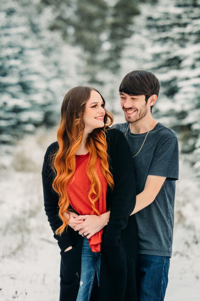 Winter proposal under snow-covered pine trees in Island Park
