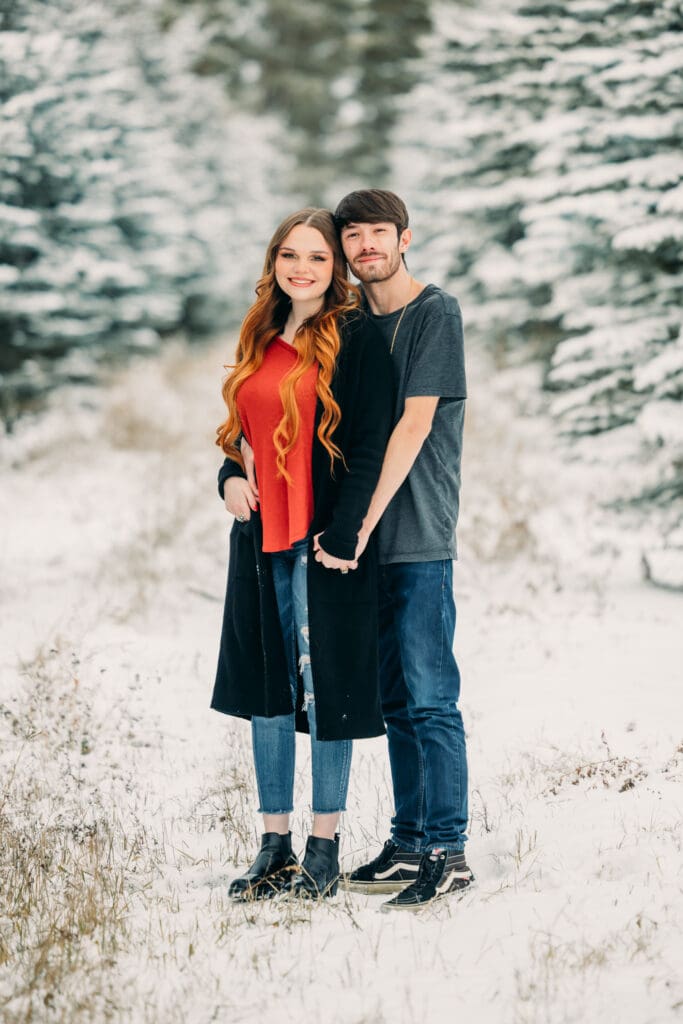 Winter proposal under snow-covered pine trees in Island Park