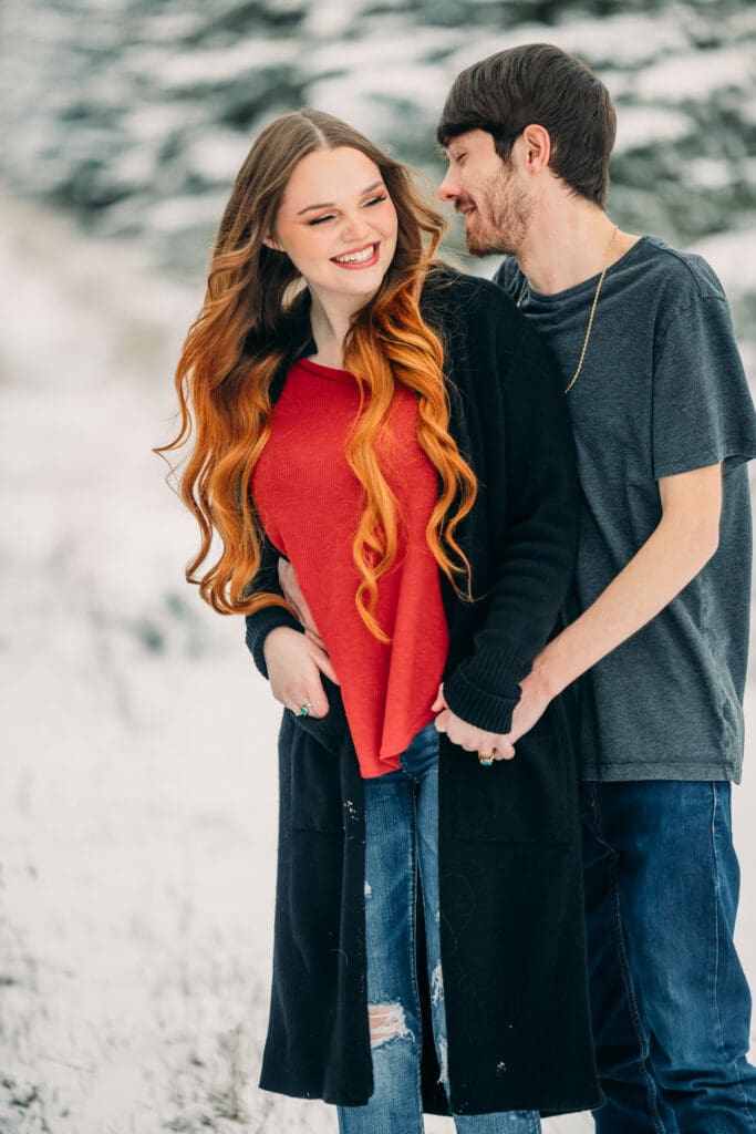 Winter proposal under snow-covered pine trees in Island Park