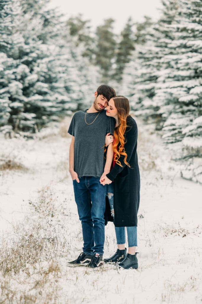 Winter proposal under snow-covered pine trees in Island Park