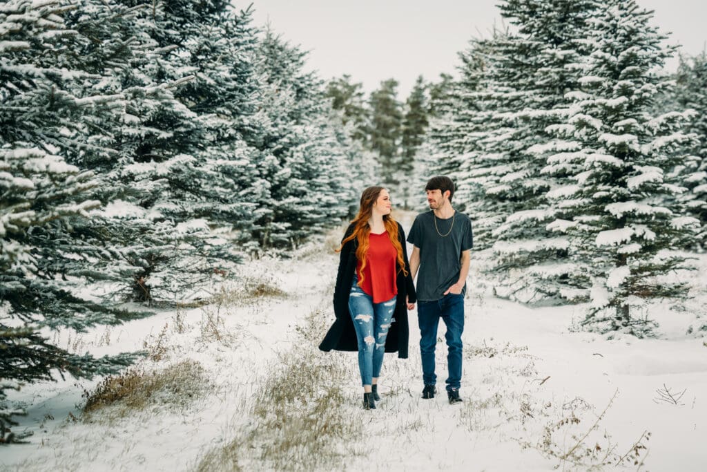 Couple embracing during a snowy engagement in Island Park, Idaho