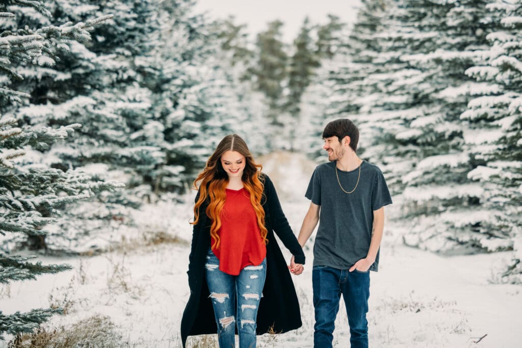 Couple embracing during a snowy engagement in Island Park, Idaho