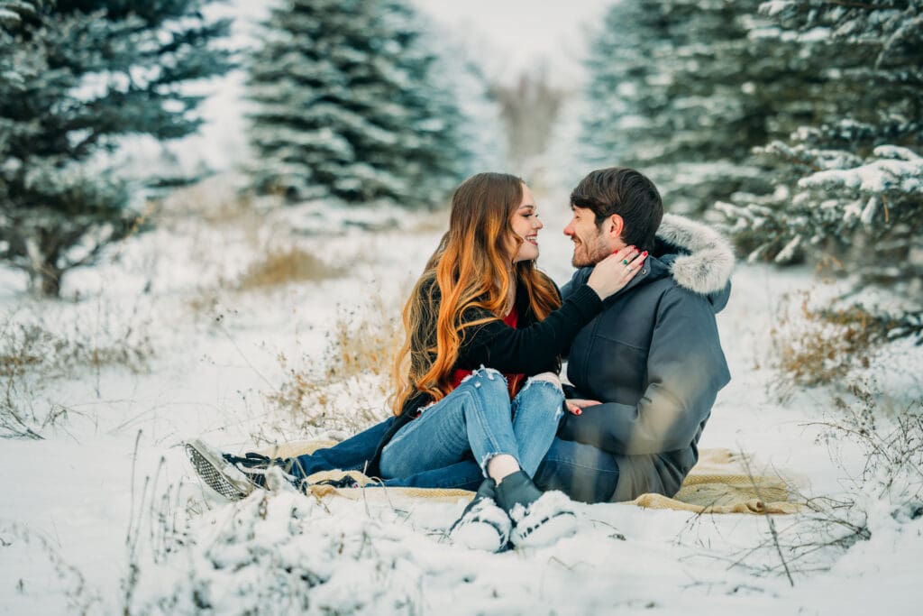 Couple embracing during a snowy engagement in Island Park, Idaho