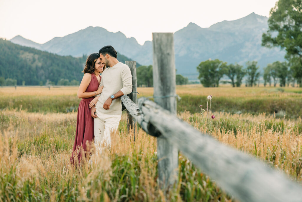 Couple Poses for Grand Teton Engagement Photo Session, playful couple by Mormon Row TA Moulton Barn