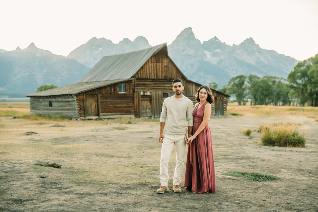Couple Poses for Grand Teton Engagement Photo Session, playful couple by Mormon Row TA Moulton Barn