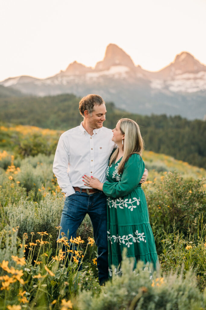Family of three embracing in a sunflower field during a sunrise session in Grand Teton National Park