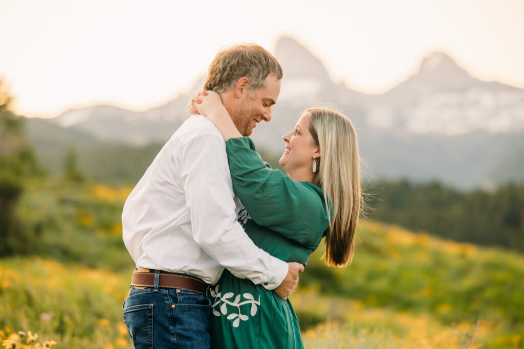 Family of three embracing in a sunflower field during a sunrise session in Grand Teton National Park