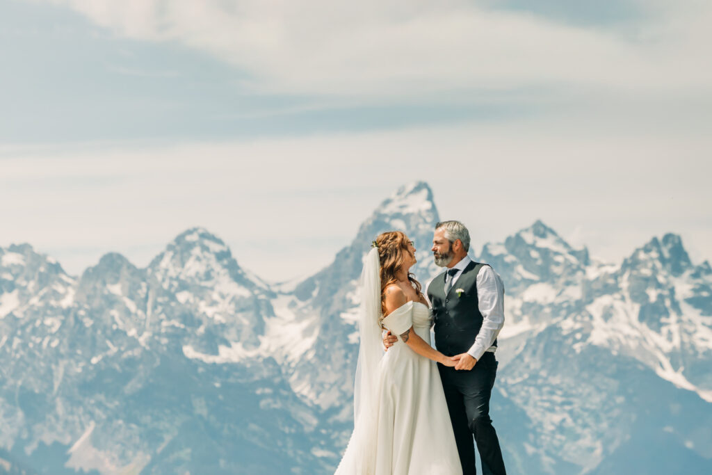 Grand Teton mountains towering above eloping couple in Wyoming national park