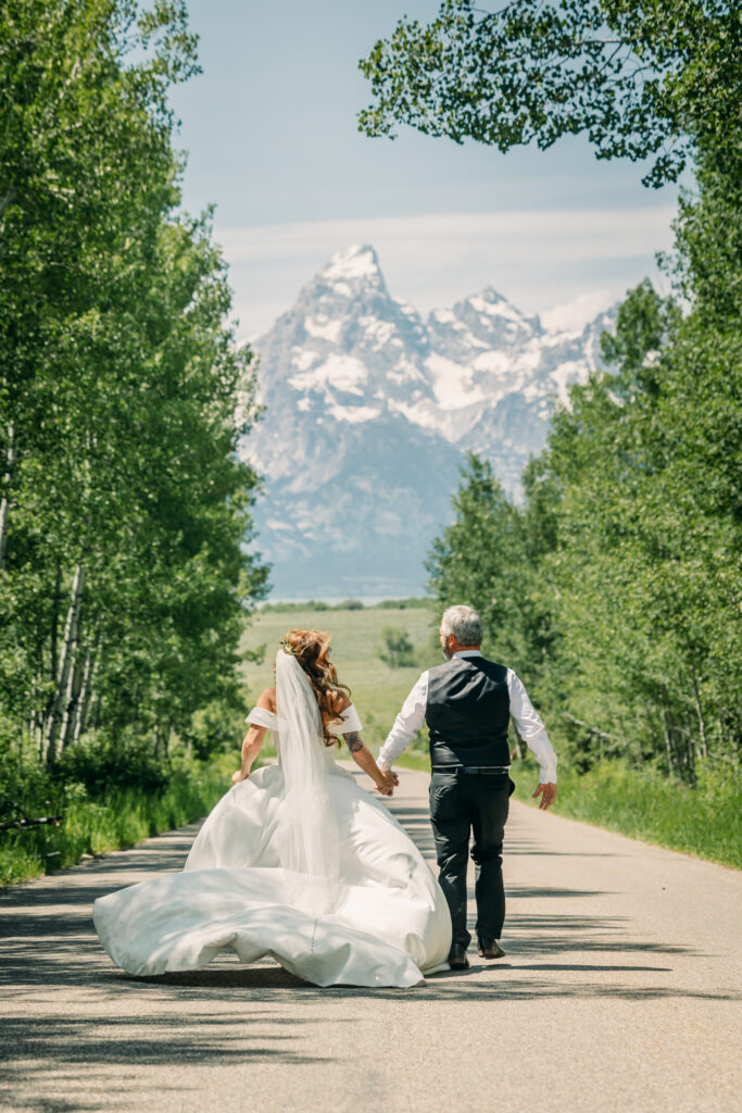 Bride and groom walking through alpine meadow in Grand Teton National Park after eloping