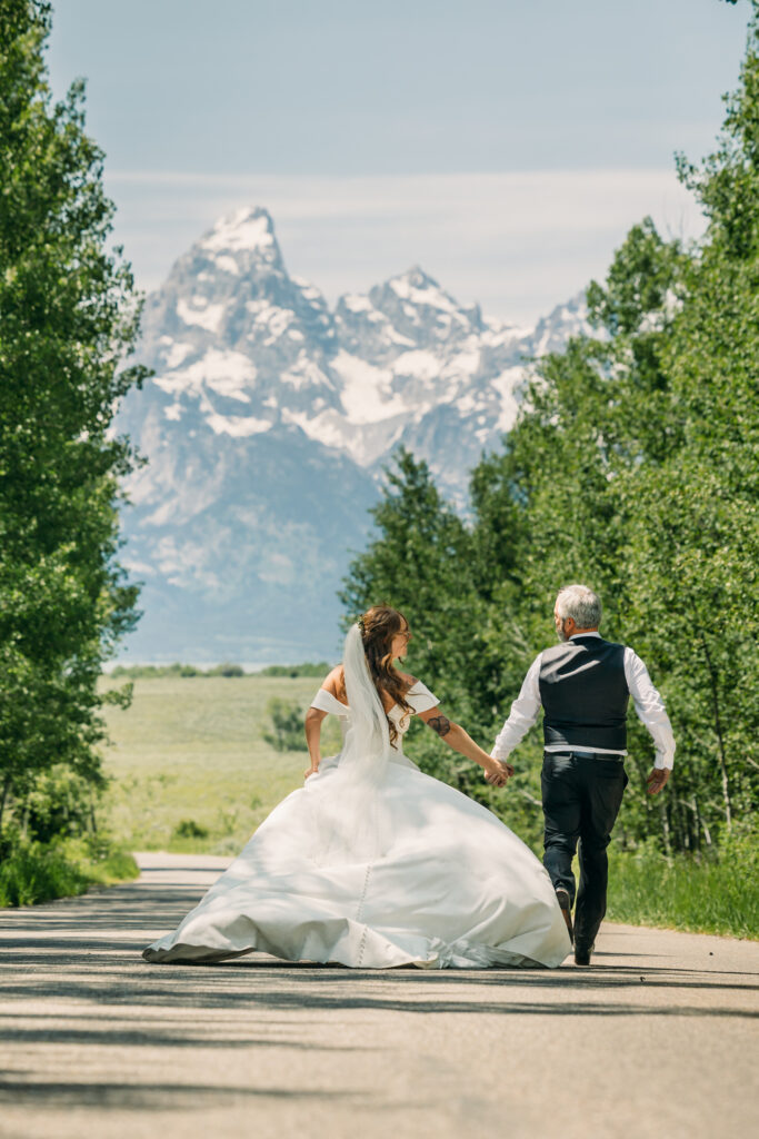 Bride and groom walking through alpine meadow in Grand Teton National Park after eloping