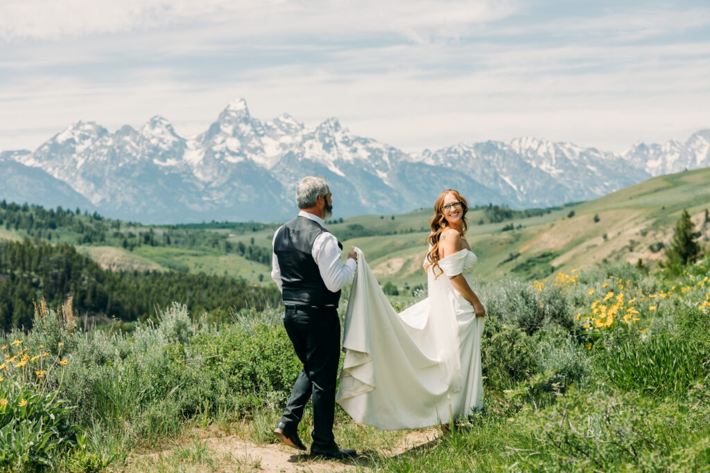 Wide landscape photo of bride and groom beneath the Tetons in Grand Teton National Park