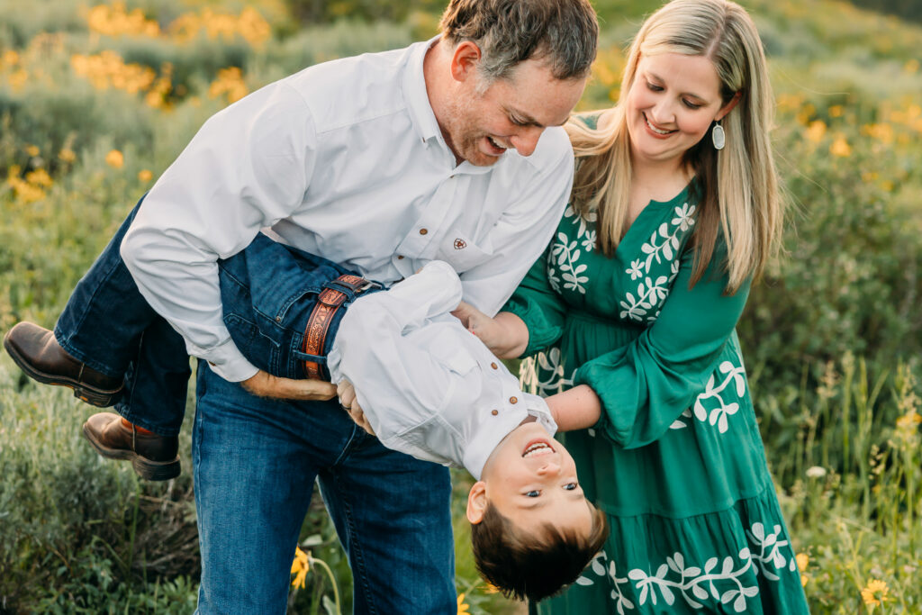 Grand Teton National Park family photographer documenting a joyful family of three at sunrise with the Tetons in the background.
