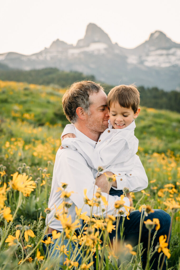 Grand Teton National Park family photographer documenting a joyful family of three at sunrise with the Tetons in the background.