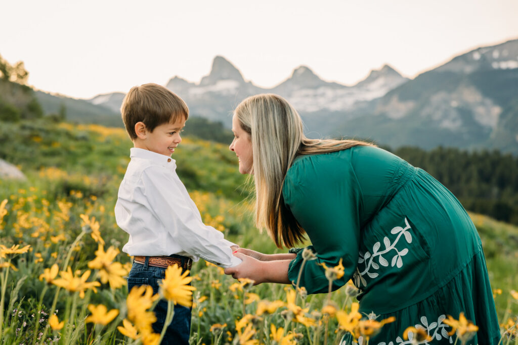 Grand Teton National Park family photographer documenting a joyful family of three at sunrise with the Tetons in the background.