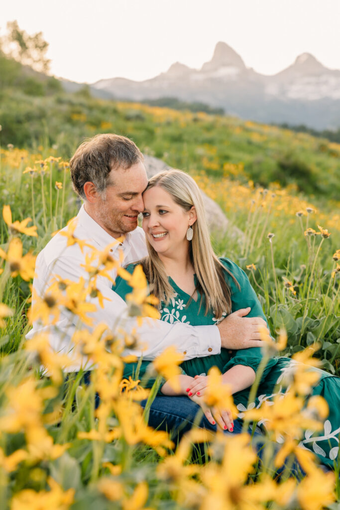 Family walking through sunflowers at sunrise during a Grand Teton National Park photography session.