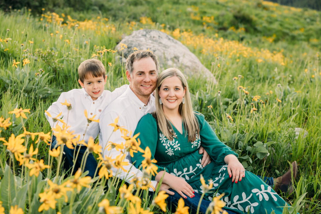 Family walking through sunflowers at sunrise during a Grand Teton National Park photography session.