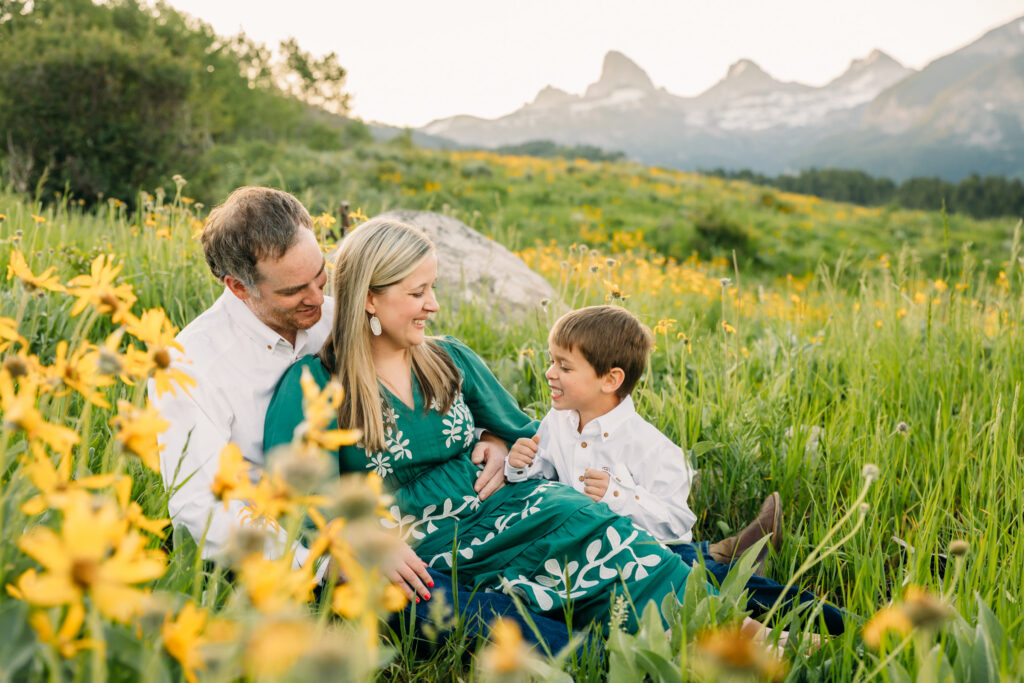 Family walking through sunflowers at sunrise during a Grand Teton National Park photography session.