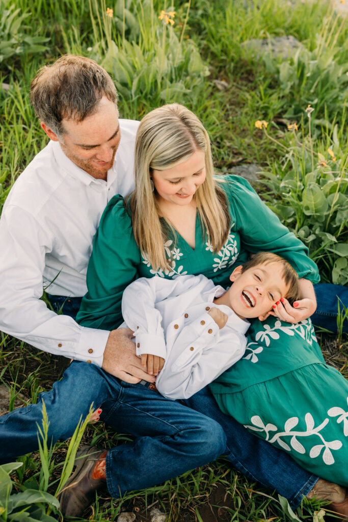 Family walking through sunflowers at sunrise during a Grand Teton National Park photography session.