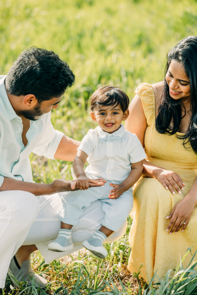 Family walking through green grass at Mormon Row Historic District with the Tetons behind them