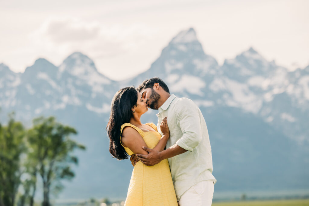 Family walking through green grass at Mormon Row Historic District with the Tetons behind them