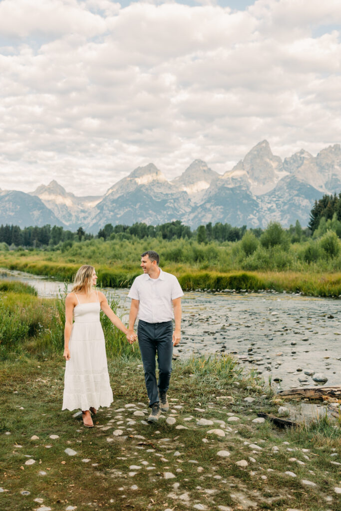 Beautiful mountain photo of couple walking in Grand Teton at Schwabacher's Landing along River