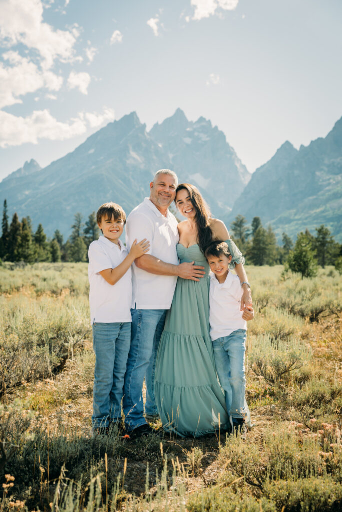 Family laughing in the meadow of Cathedral Turnout in Grand Teton surrounded by sagebrush