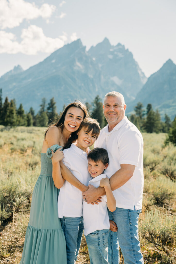 Family laughing in the meadow of Cathedral Turnout in Grand Teton surrounded by sagebrush