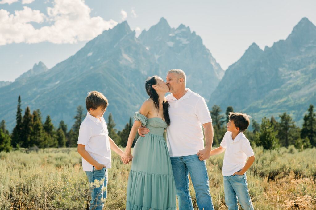 Family laughing in the meadow of Cathedral Turnout in Grand Teton surrounded by sagebrush