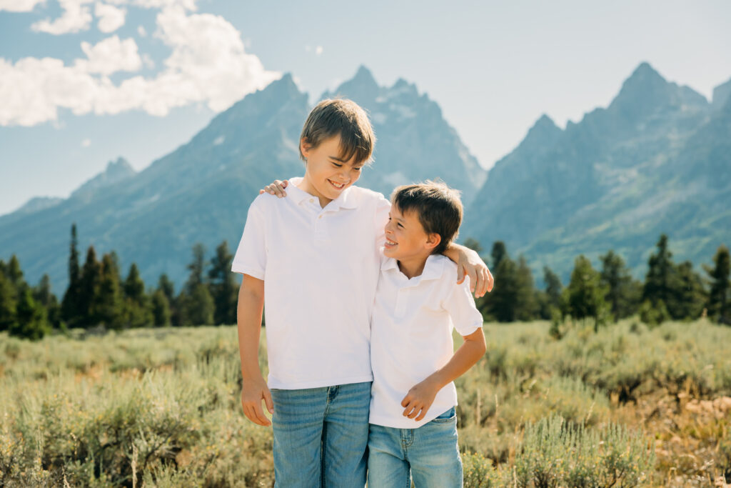 Family laughing in the meadow of Cathedral Turnout in Grand Teton surrounded by sagebrush