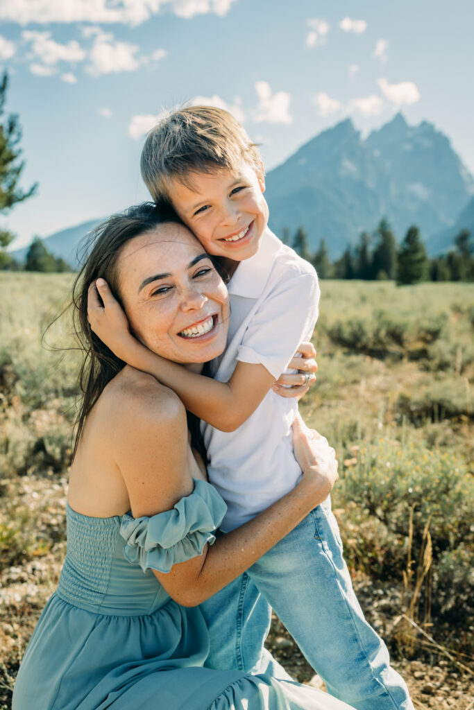 Family laughing in the meadow of Cathedral Turnout in Grand Teton surrounded by sagebrush