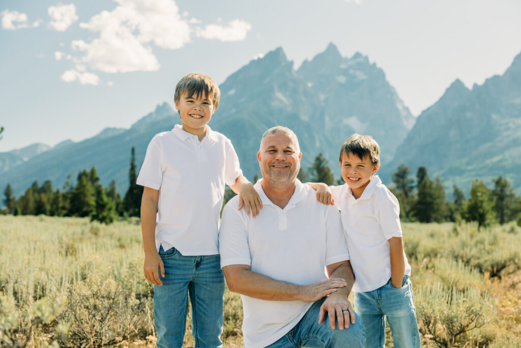 Family laughing in the meadow of Cathedral Turnout in Grand Teton surrounded by sagebrush