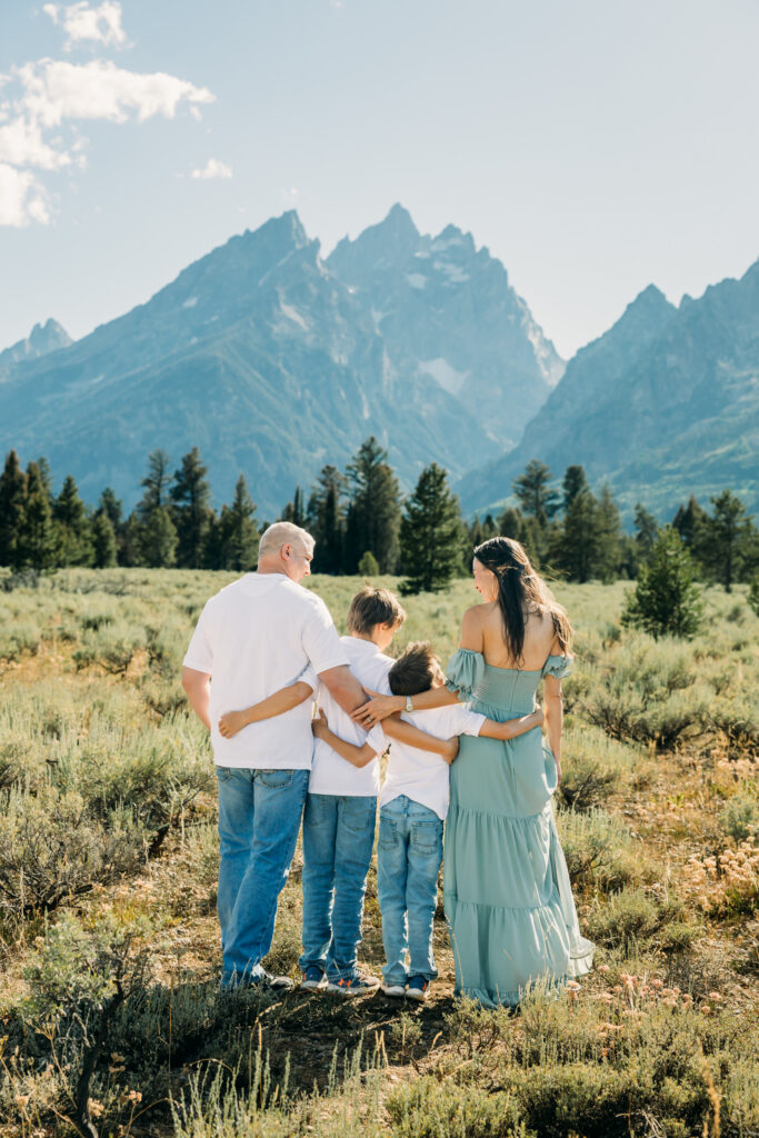 Family laughing in the meadow of Cathedral Turnout in Grand Teton surrounded by sagebrush