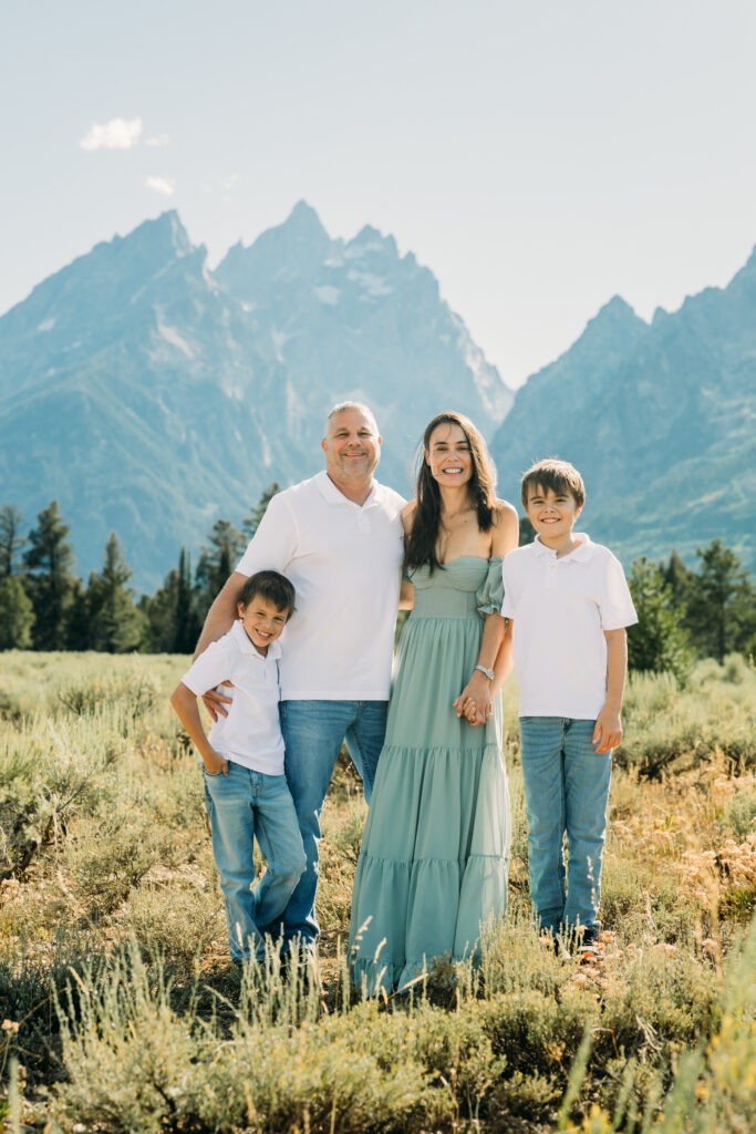 Family laughing in the meadow of Cathedral Turnout in Grand Teton surrounded by sagebrush