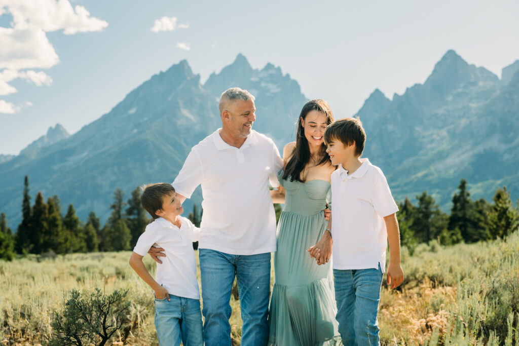 Family laughing in the meadow of Cathedral Turnout in Grand Teton surrounded by sagebrush