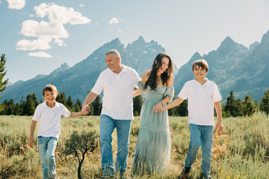 Family laughing in the meadow of Cathedral Turnout in Grand Teton surrounded by sagebrush
