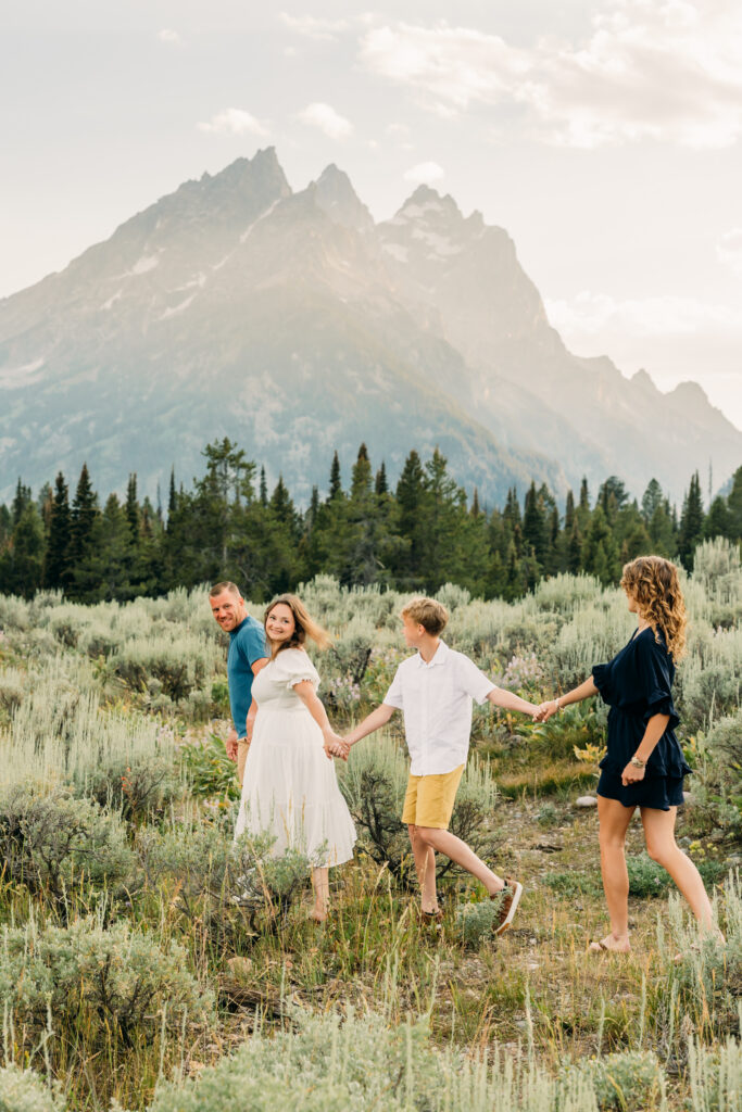 Mother and father hugging their kids during a mountain photo session in Grand Teton National Park Cascade Canyon Turnout