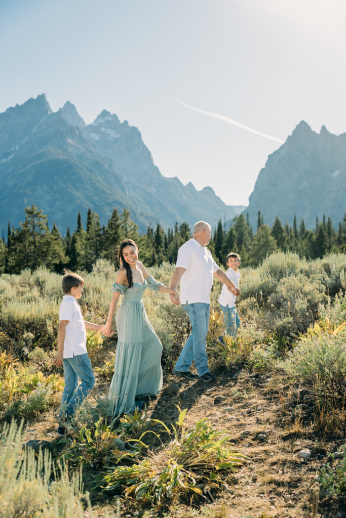 Jackson Hole family photographer afternoon session in the park with mountains in background and kids in meadow