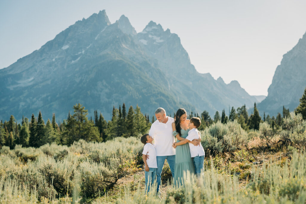 Jackson Hole family photographer afternoon session in the park with mountains in background and kids in meadow