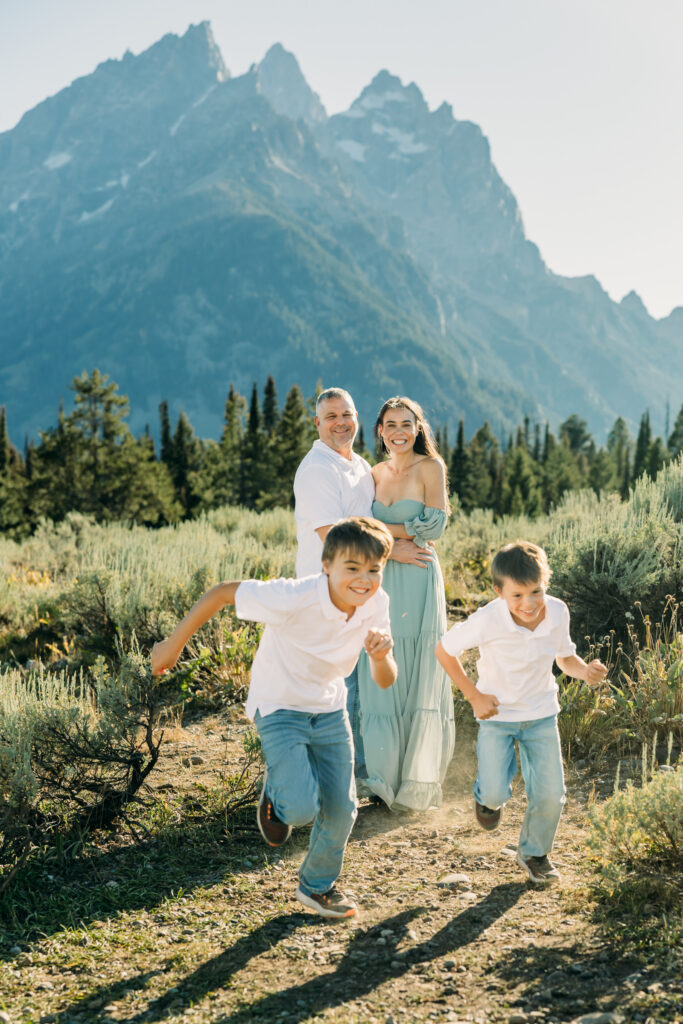 Jackson Hole family photographer afternoon session in the park with mountains in background and kids in meadow