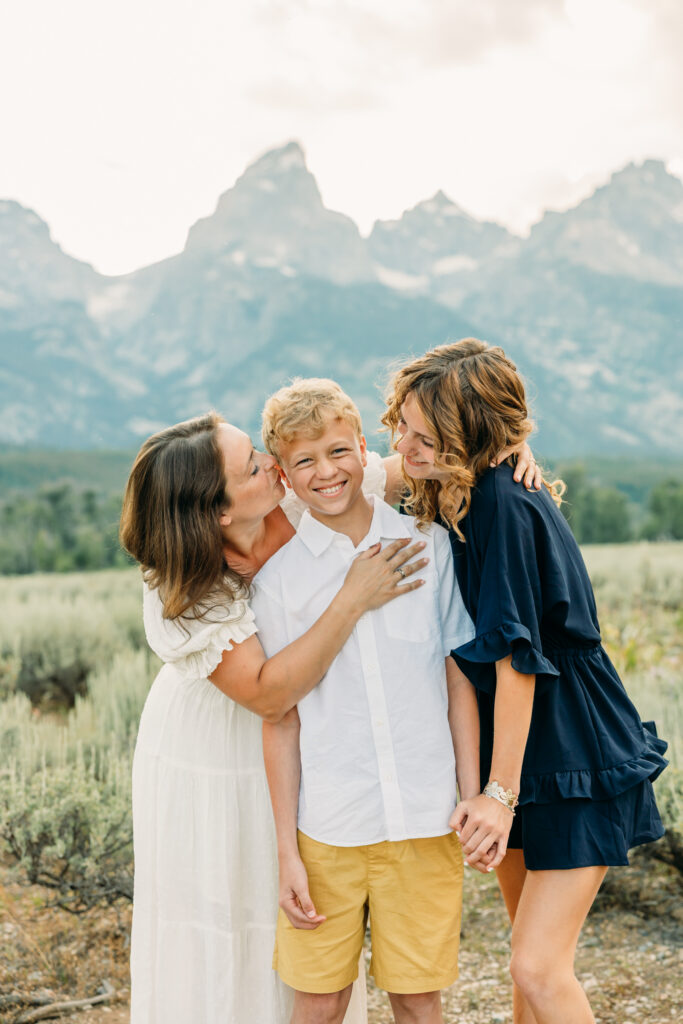 Family portraits with scenic Wyoming mountain backdrop at Cascade Canyon Turnout in Grand Teton National Park at sunset