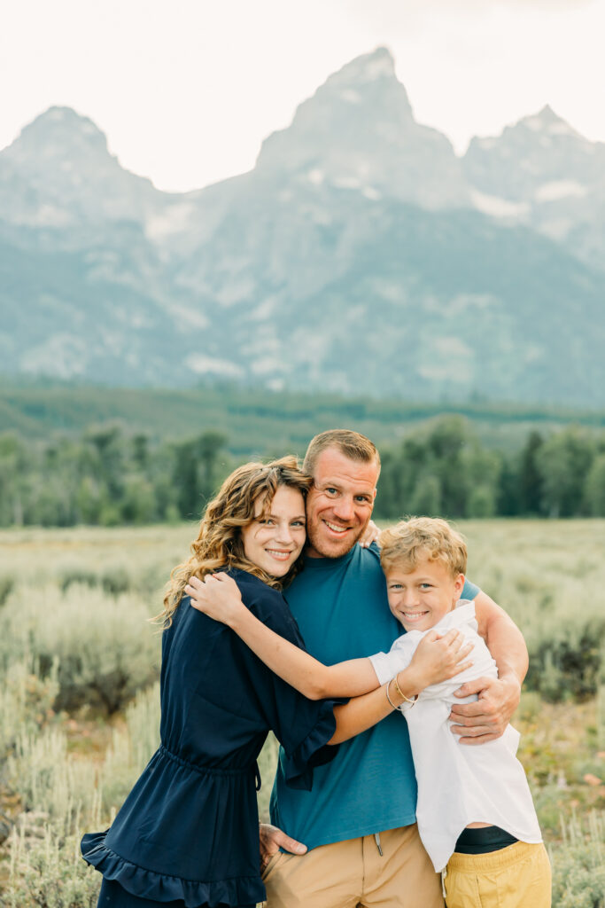 Family portraits with scenic Wyoming mountain backdrop at Cascade Canyon Turnout in Grand Teton National Park at sunset