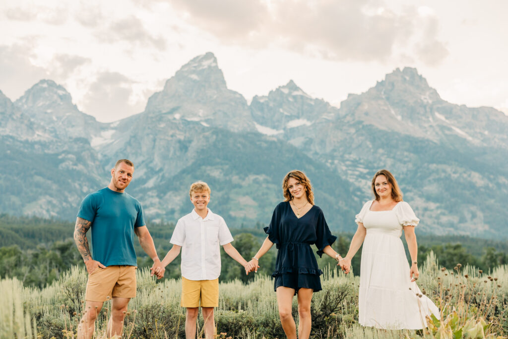 Family portraits with scenic Wyoming mountain backdrop at Cascade Canyon Turnout in Grand Teton National Park at sunset
