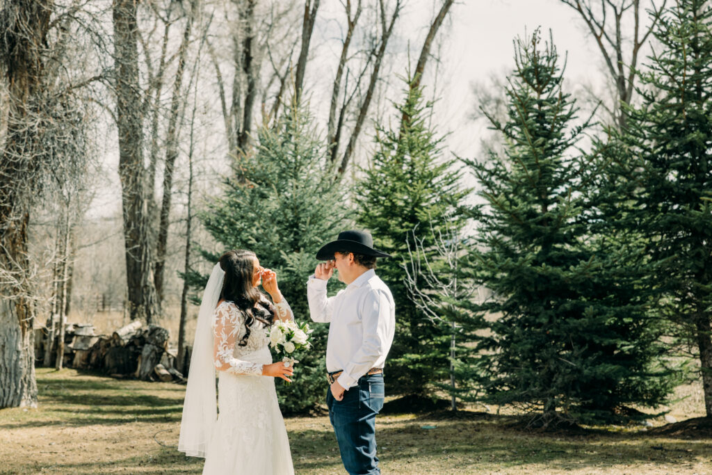 Bride and groom with Teton mountains during Jackson Hole wedding first look crying